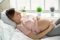 Young preganant woman expecting a baby relaxing on bed indoors Royalty Free Stock Photo