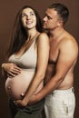 A young pregnant brunette woman is hugging with a torso man. Waiting for birth and tenderness. Royalty Free Stock Photo