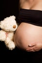 Young pregnant Caucasian woman holding teddy bear