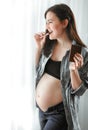 Young pregnant cheerful beautiful woman eating chocolate Royalty Free Stock Photo