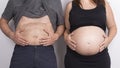 Young pregnant couple showing their bellies