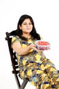 Young pregnant lady is holding watermelon in hand with sitting on the chair and smile face Royalty Free Stock Photo