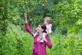 Young pregnant mother in apple garden with her baby Royalty Free Stock Photo