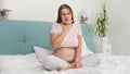 Young pregnant woman awake in the morning feeling unwell suffering from nausea. Intoxication during pregnancy