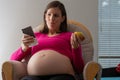 Pregnant woman deciding between a a healthy choice of an apple and an unhealthy chocolate