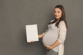 Young pregnant woman with blank white paper Royalty Free Stock Photo