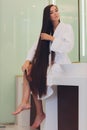 Young pregnant woman brushes long hair in a bathroom. Royalty Free Stock Photo