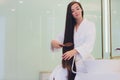 Young pregnant woman brushes long hair in a bathroom. Royalty Free Stock Photo