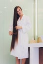 Young pregnant woman brushes long hair in a bathroom. Royalty Free Stock Photo