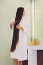 Young pregnant woman brushes long hair in a bathroom. Royalty Free Stock Photo