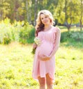 Young pregnant woman with chamomiles flowers in summer Royalty Free Stock Photo