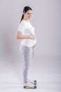 Young pregnant woman checking weight Royalty Free Stock Photo