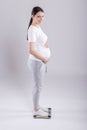 Young pregnant woman checking weight Royalty Free Stock Photo