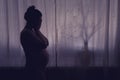 Young pregnant woman crying with her hands folded near her face. Pregnancy problems, silhouette of the expectant mother at the Royalty Free Stock Photo