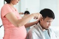 Young Pregnant Woman cutting husband hair with clipper at home Royalty Free Stock Photo