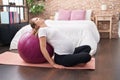 Young pregnant woman doing prepartum exercise leaning on fit ball at bedroom Royalty Free Stock Photo