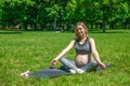 Young pregnant woman doing sport exercises on green grass in the park. Royalty Free Stock Photo