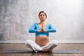 Young pregnant woman doing yoga exercises and meditating at home. Health care, mindfulness, relaxation and wellness