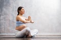 Young pregnant woman doing yoga exercises and meditating at home. Health care, mindfulness, relaxation and wellness