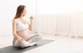 Young pregnant woman drinking water during yoga training Royalty Free Stock Photo