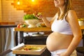 Young pregnant woman eating pizza at the kitchen Royalty Free Stock Photo