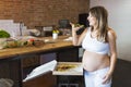 Young pregnant woman eating pizza at the kitchen Royalty Free Stock Photo