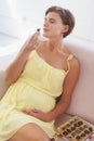 These are divine. A young pregnant woman enjoying a box of chocolates all to herself. Royalty Free Stock Photo