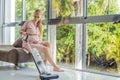 Young pregnant woman enjoys cleaning her house. Easy cleaning with a wireless vacuum cleaner. Pregnant woman cleaning Royalty Free Stock Photo