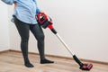 Young pregnant woman enjoys cleaning her house. Modern easy cleaning. Easy cleaning with a wireless vacuum cleaner Royalty Free Stock Photo