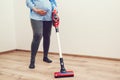 Young pregnant woman enjoys cleaning her house. Modern easy cleaning. Easy cleaning with a wireless vacuum cleaner Royalty Free Stock Photo