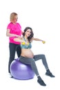 Young pregnant woman exercising with physiotherapist in birthing school. Doctor`s help conceptat in antenatal class Royalty Free Stock Photo