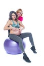 Young pregnant woman exercising with physiotherapist in birthing school. Doctor`s help conceptat in antenatal class Royalty Free Stock Photo