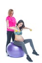 Young pregnant woman exercising with physiotherapist in birthing school. Doctor`s help conceptat in antenatal class Royalty Free Stock Photo