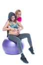 Young pregnant woman exercising with physiotherapist in birthing school. Doctor`s help conceptat in antenatal class Royalty Free Stock Photo