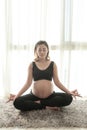 Young Pregnant woman exercising yoga on mat in room Royalty Free Stock Photo