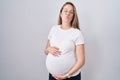 Young pregnant woman expecting a baby, touching pregnant belly looking at the camera blowing a kiss being lovely and sexy Royalty Free Stock Photo