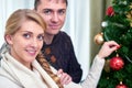 Young pregnant woman and happy father decorating christmas tree