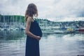 Young pregnant woman by the harbor