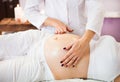 Young pregnant woman having abdominal massage at beauty spa salon. Close-up. Spa treatment Royalty Free Stock Photo