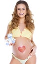 Young pregnant woman with heart shape pained