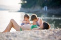 Young pregnant woman and her children on the beach on sunrise