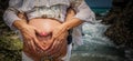 Young pregnant woman with her hands and those of her partner making a heart in her belly on the beach Royalty Free Stock Photo