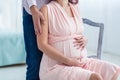 Young pregnant woman with her husband expecting the baby. Pregnancy, maternity, preparation and expectation concept. Beautiful Royalty Free Stock Photo