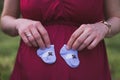 Young pregnant woman holding baby socks in her hands Royalty Free Stock Photo