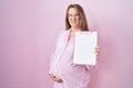 Young pregnant woman holding clipboard clueless and confused expression Royalty Free Stock Photo