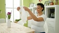 Young pregnant woman holding pyjama sitting on table at dinning room Royalty Free Stock Photo