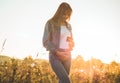 Young Pregnant Woman holding ultrasound photo at Sunset and Embracing her Belly. 4 Month Pregnancy. Maternity Concept. Toned Photo Royalty Free Stock Photo