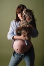 Young pregnant woman holds  big cat in her arms, big bare belly sticks out Royalty Free Stock Photo