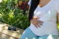 A young pregnant woman holds her hands on her tummy and feels the tremors of her baby Royalty Free Stock Photo