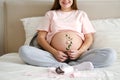 Young pregnant woman in home clothes strokes her big belly Royalty Free Stock Photo